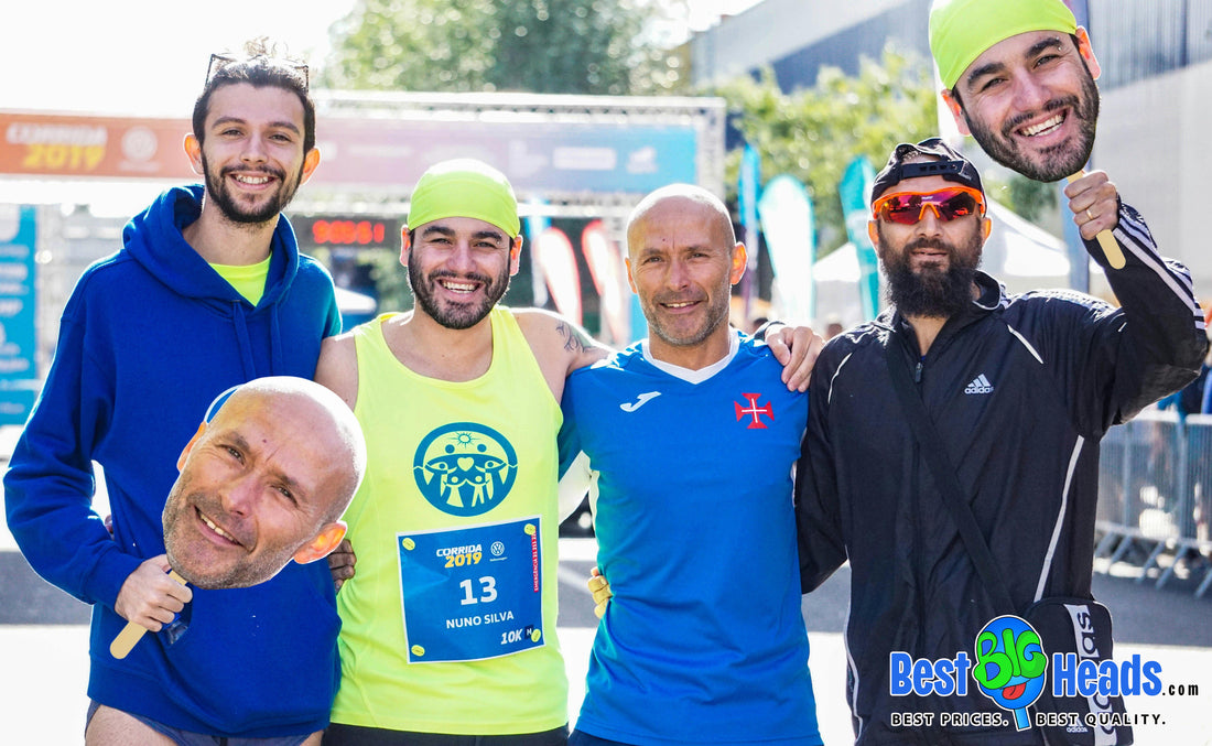 A group of friends proudly holding big head cutouts as they gather around and celebrate their friend after his game.