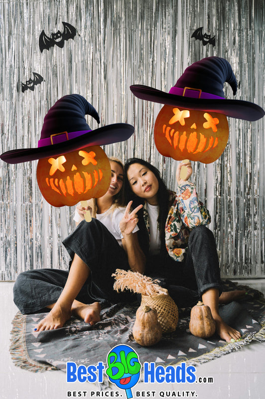 Two girls enjoy celebrating Halloween, holding up big pumpkin head cutouts, adding a playful and festive touch to the spooky occasion.