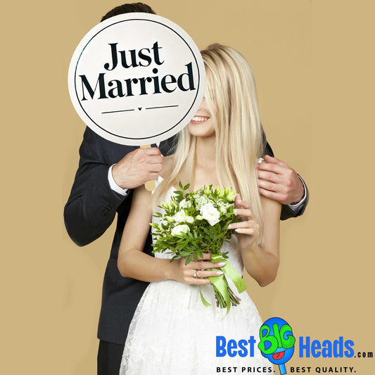 A joyful photo of the newlyweds posing together, holding a "Just Married" cutout. The couple’s radiant smiles and the playful prop capture the happiness and excitement of their special day, set against a beautifully decorated wedding backdrop.