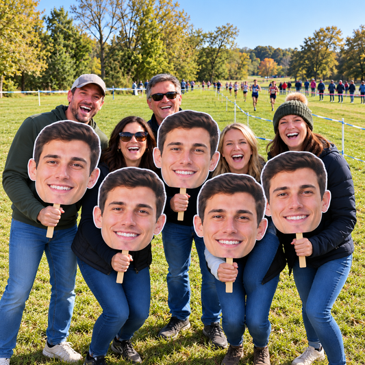 Five supporters holding matching oversized runner face cutouts beside a roped grass cross-country course.