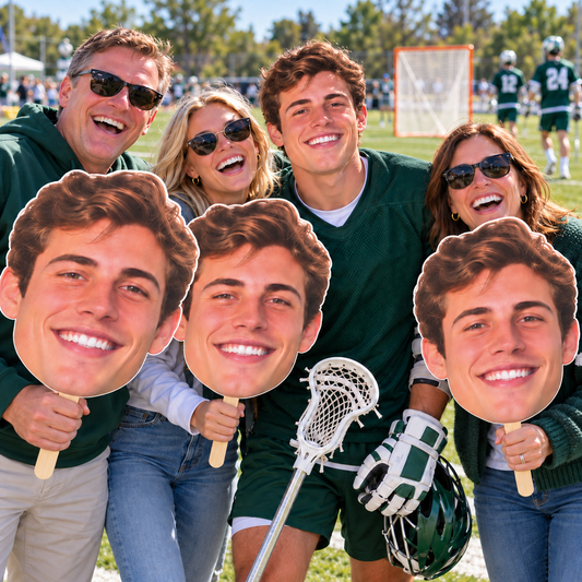 Lacrosse player celebrating with family holding three huge matching face cutouts, with a lacrosse stick, helmet and goal clearly visible