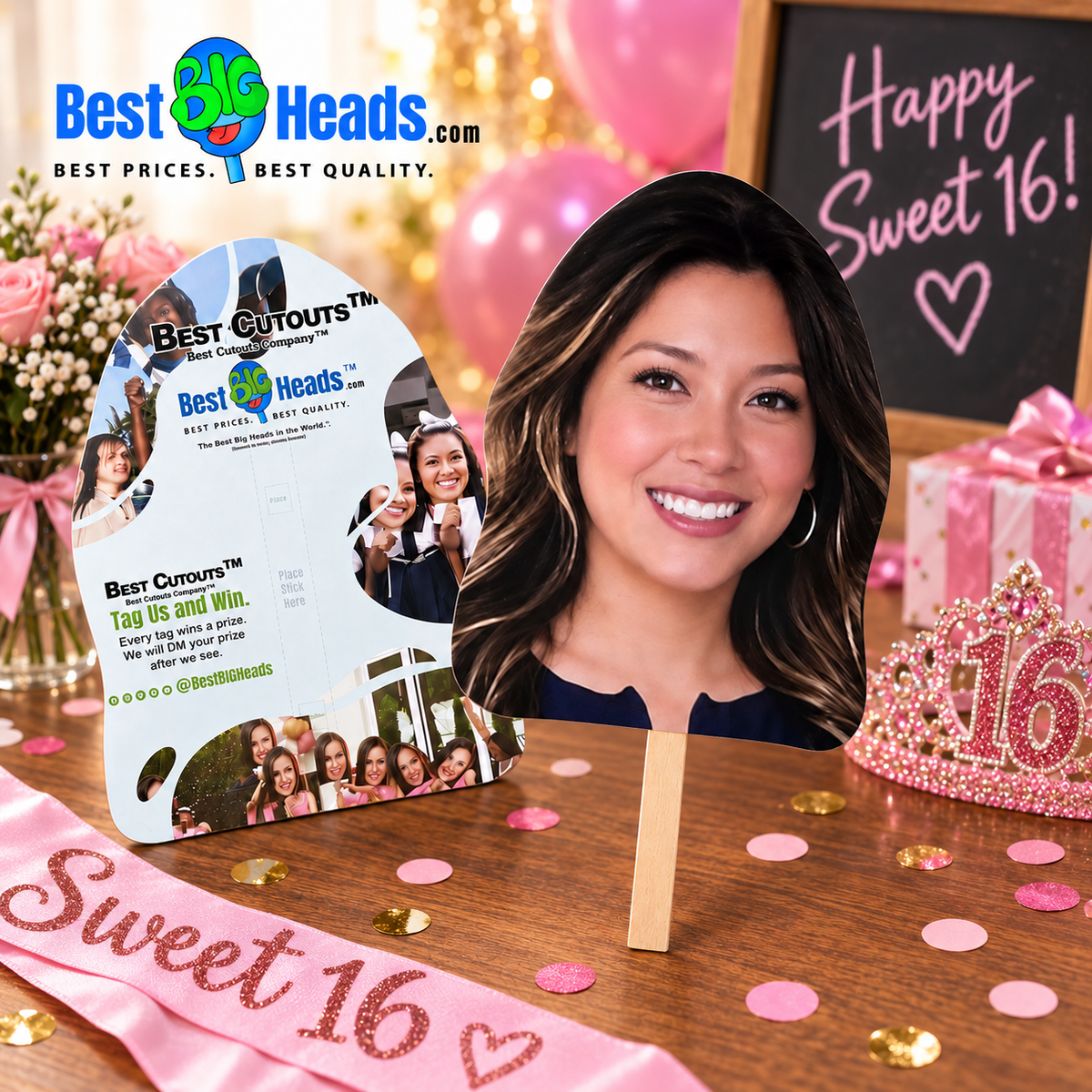 A 16th birthday party setup featuring a die-cut cardboard cutout of a smiling woman on a wooden stand, alongside a pink 'Sweet 16' sash, pink tiara, balloons, and a 'Happy Sweet 16!' chalkboard sign. The 'Best Heads.